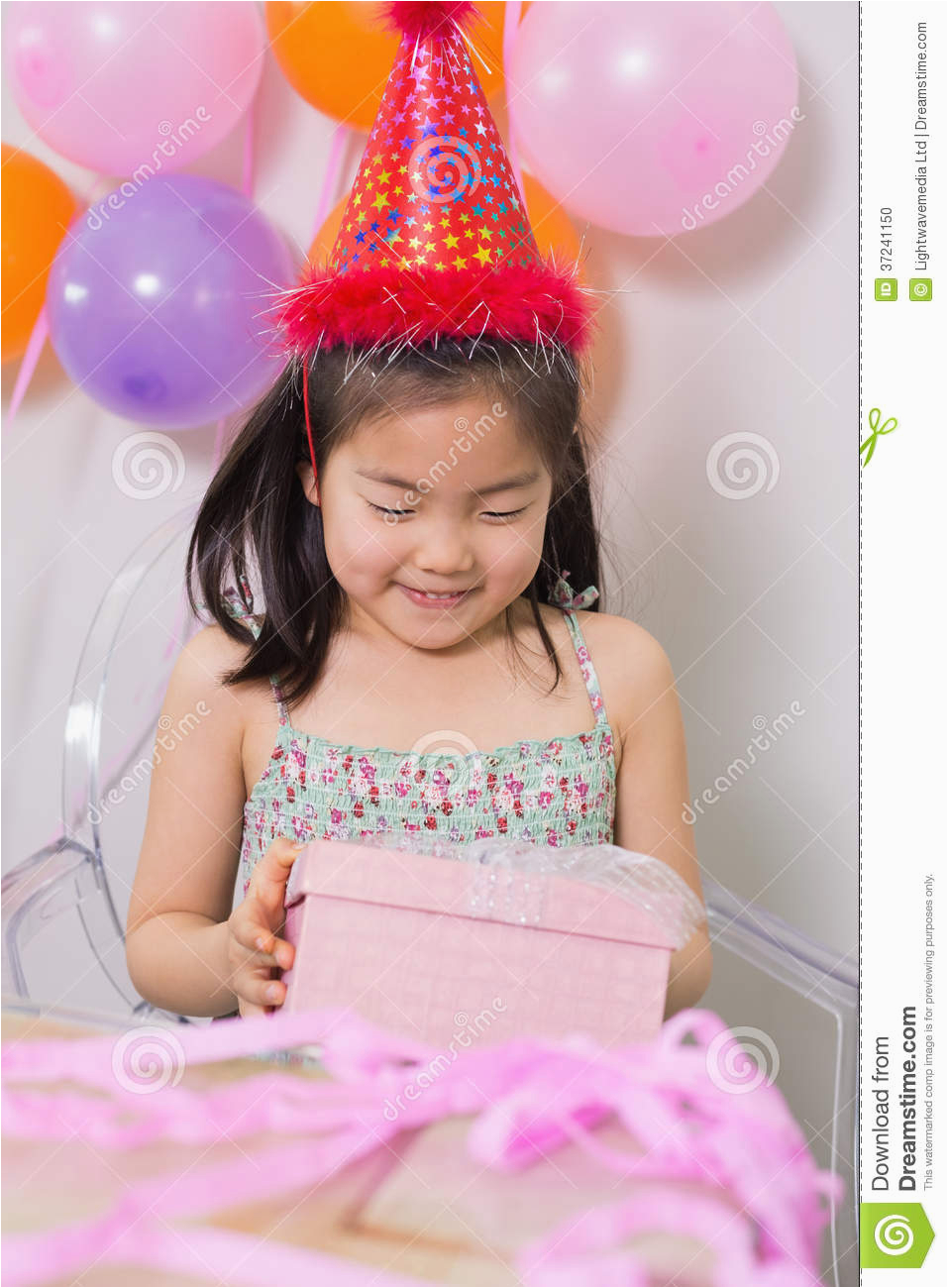 little girl with gift box at her birthday party stock